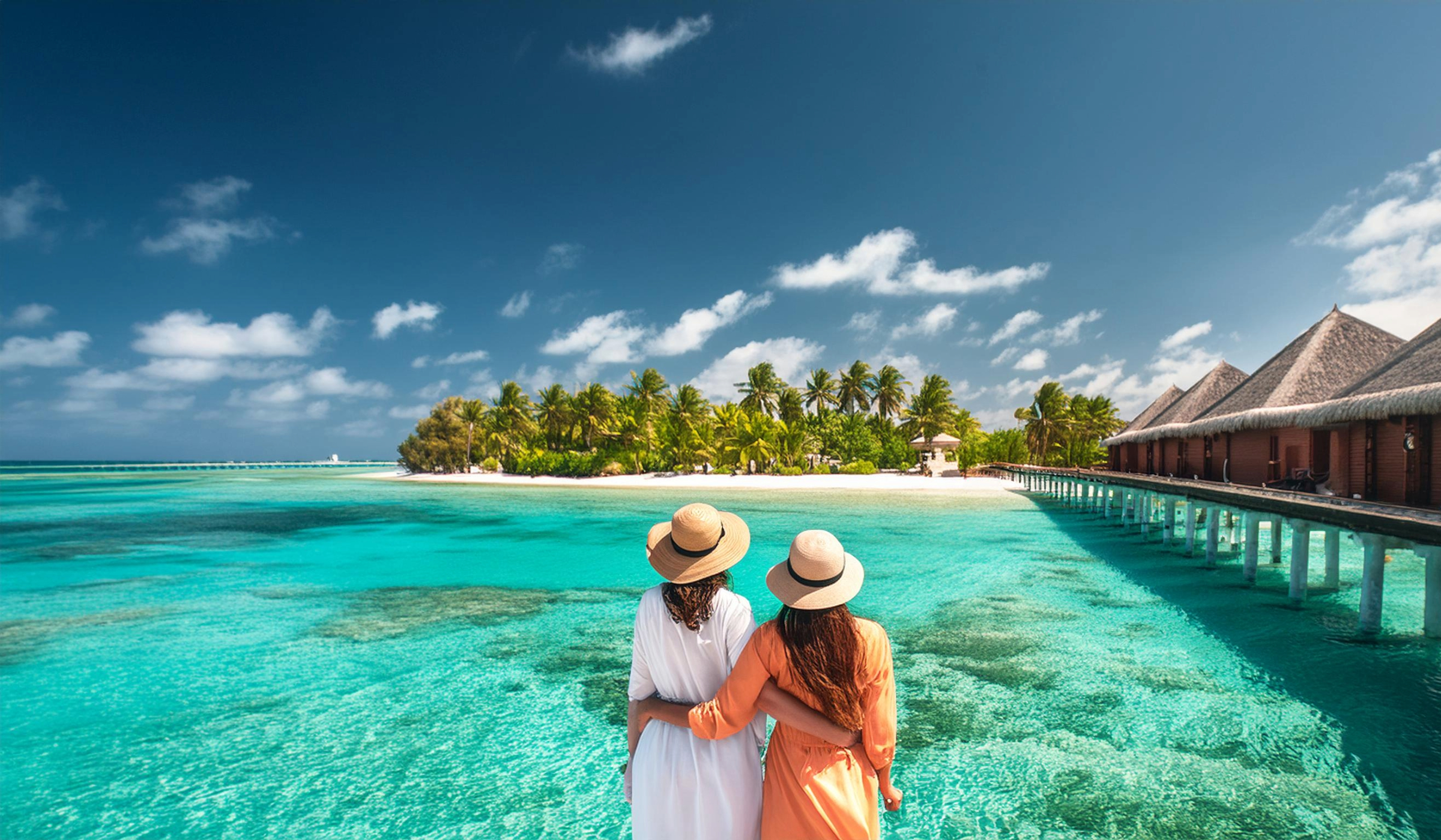 zwei-frauen-stehen-vor-dem-strand-in-ihrem-malediven-urlaub